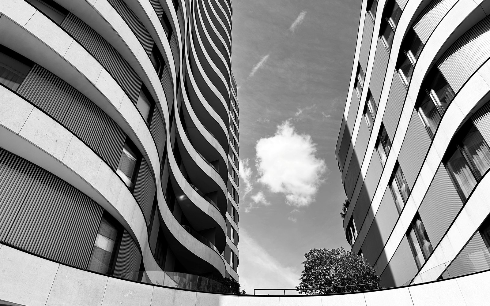Black and white photograph of two curved form apartment towers.