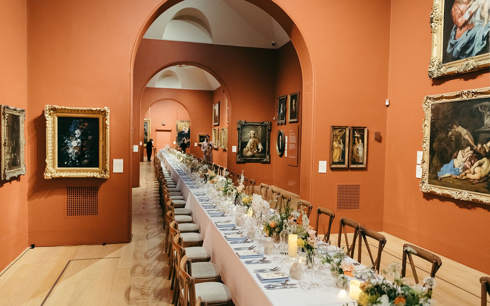 Gallery space set with long table and chairs and flower decorations.