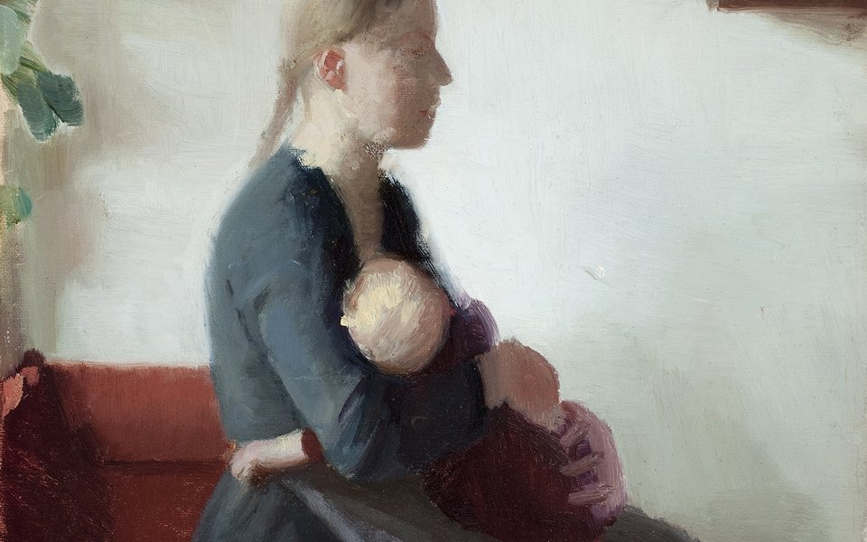 A woman sat breastfeeding a baby