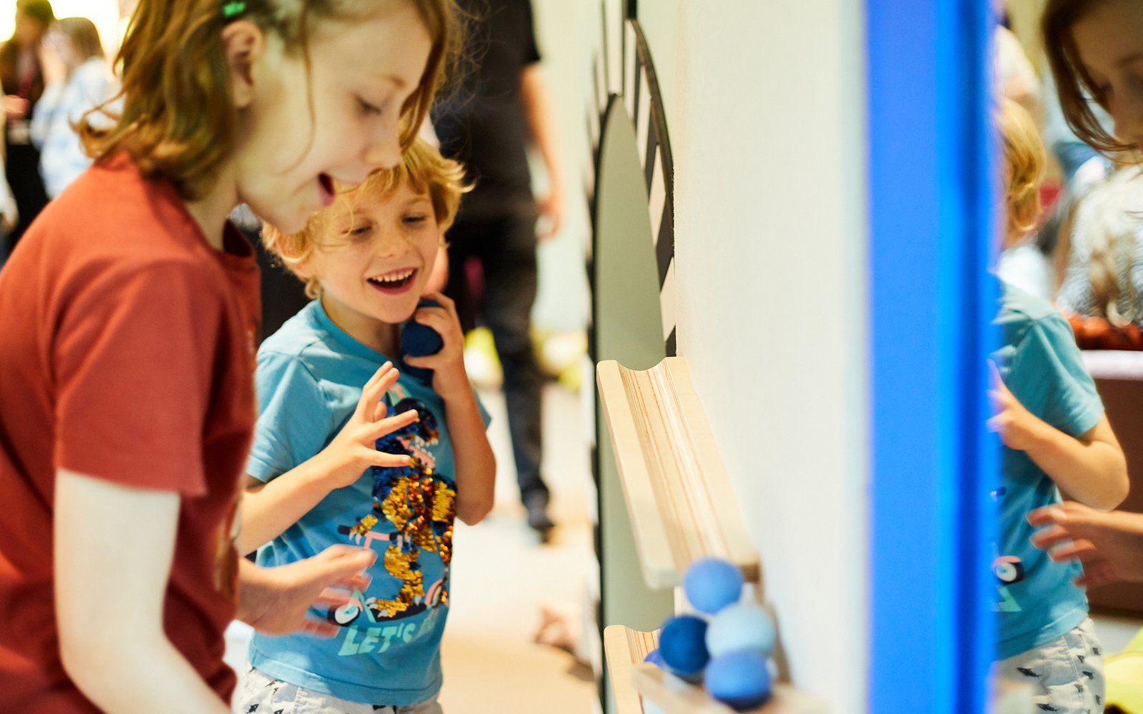 Two children playing with ball slide