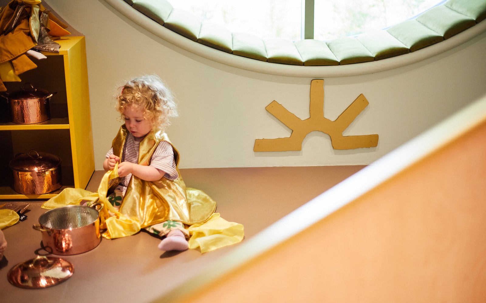 Child in dress sat on floor playing
