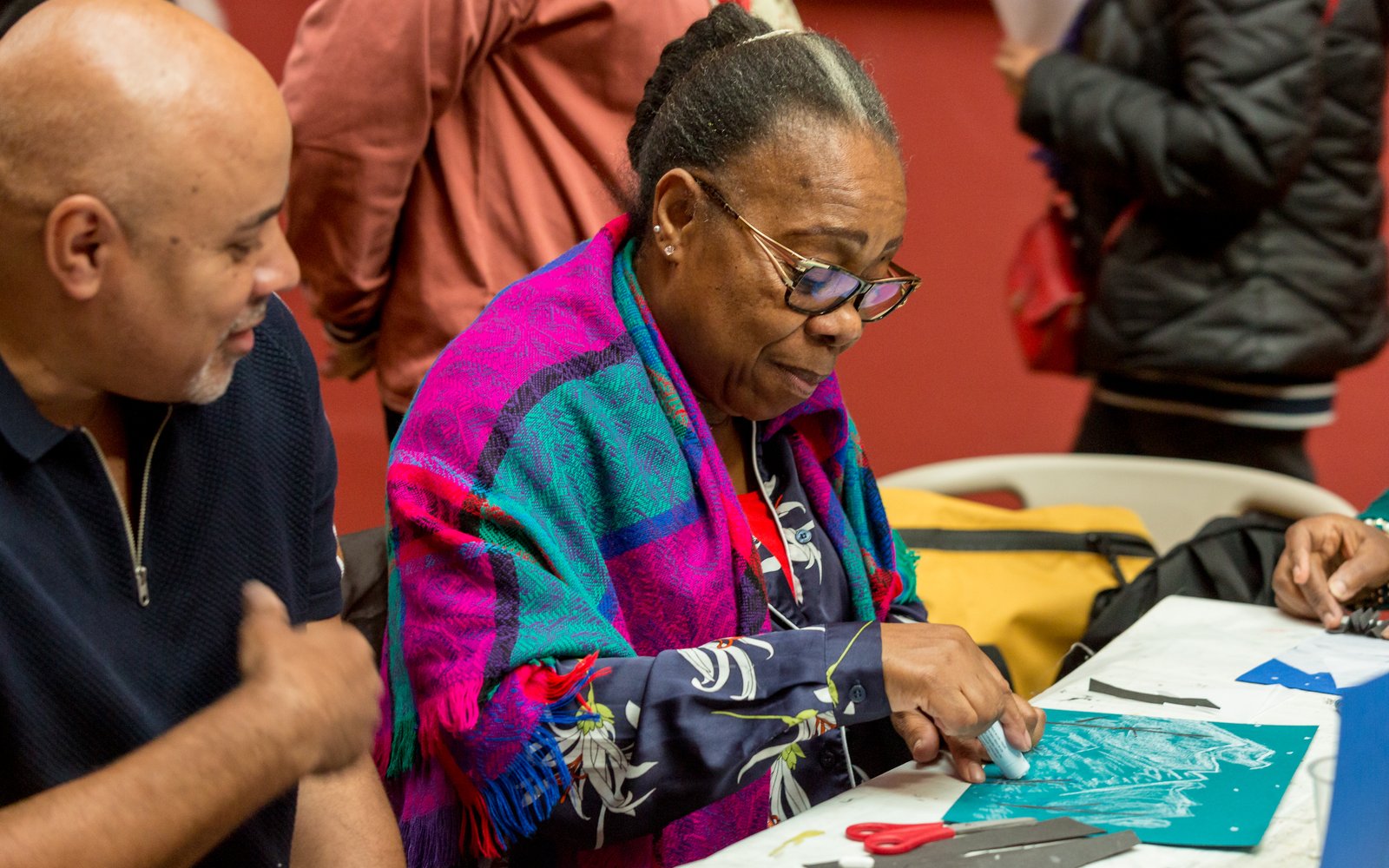Two people sit at a table crafting