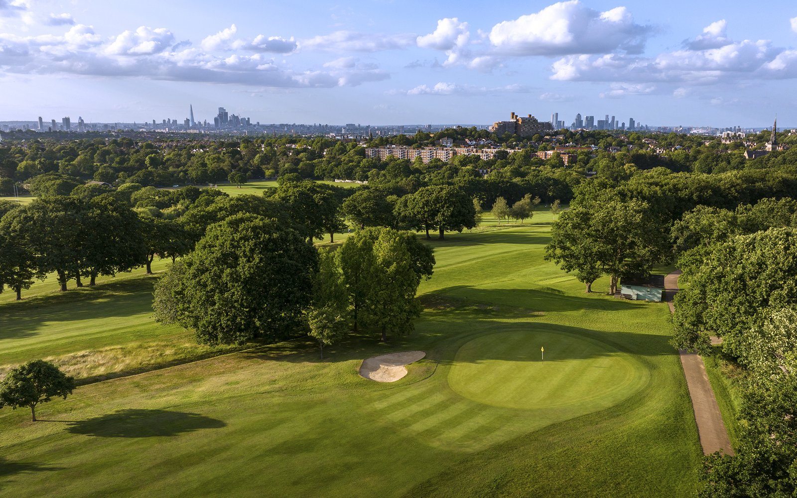 A golf course from above with a view of the city of London