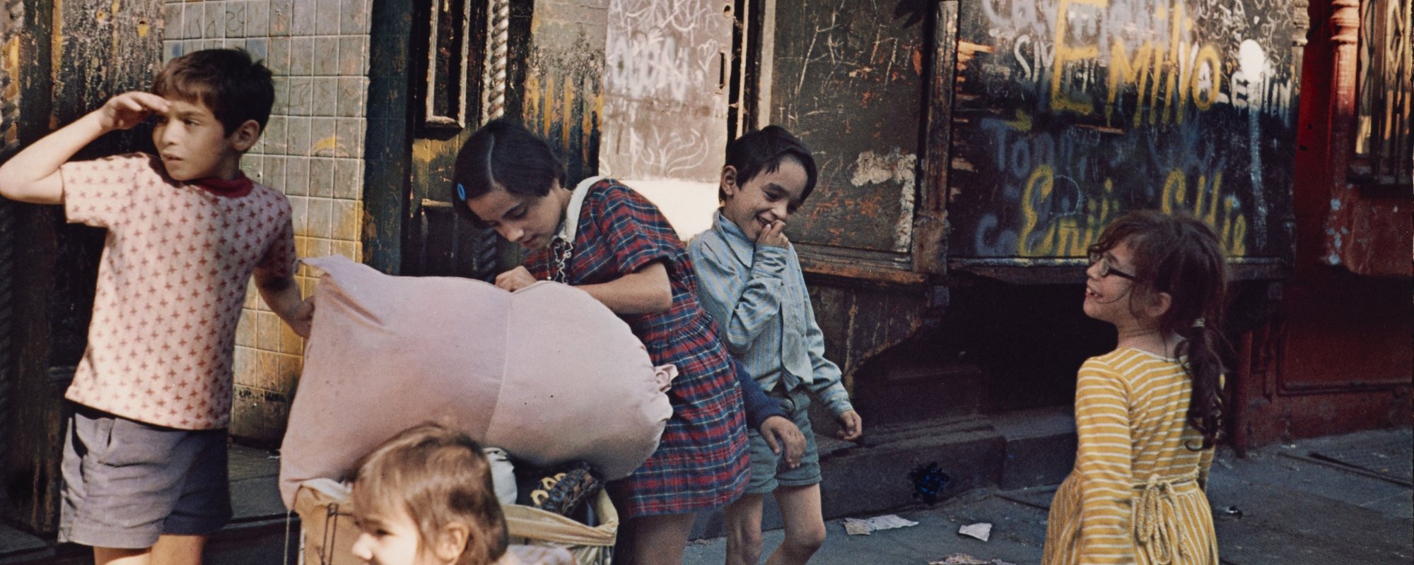 A group of children playing in front of a shop.