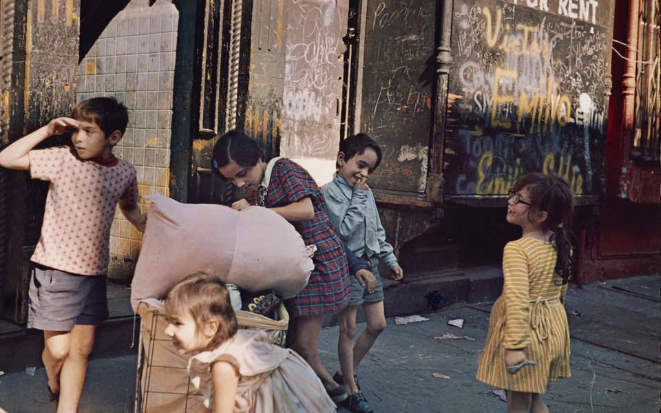 A group of children playing in front of a shop.