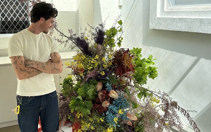 A man stood in front of a large floral display