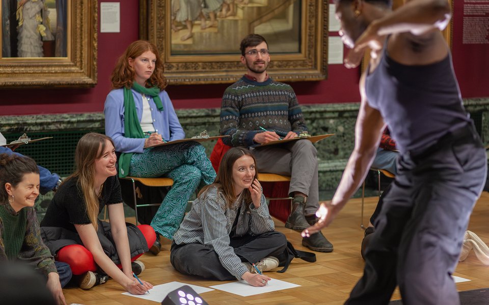 A group taking part in a life drawing class.