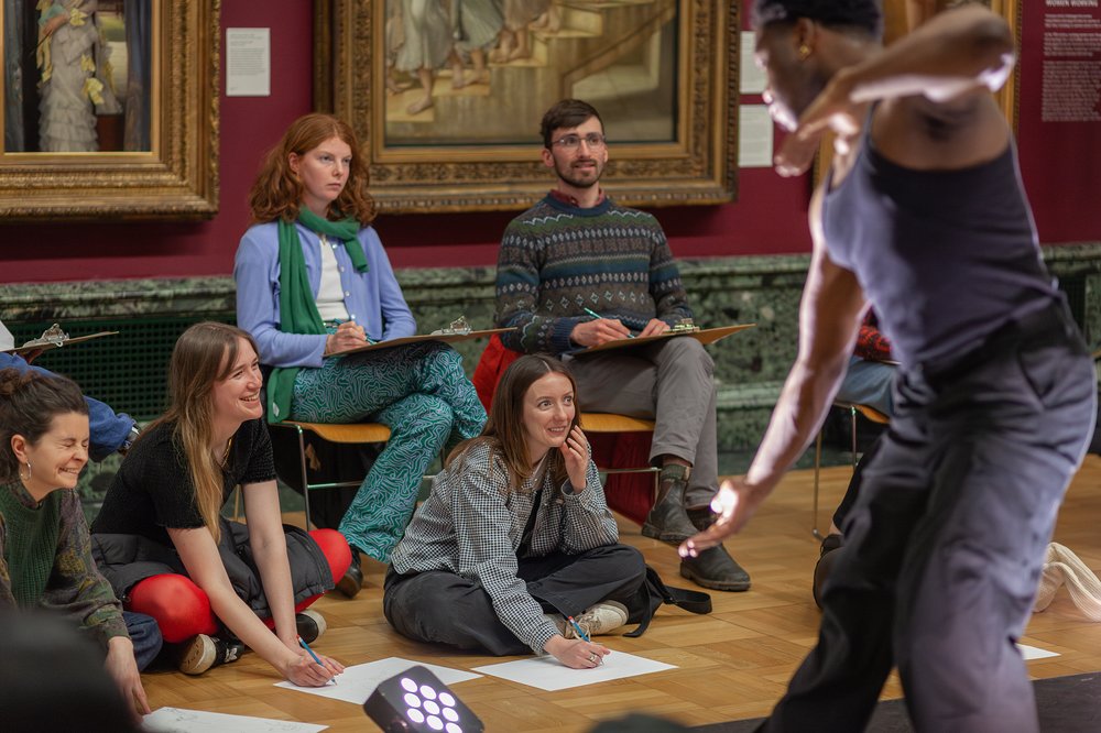 A group taking part in a life drawing class.