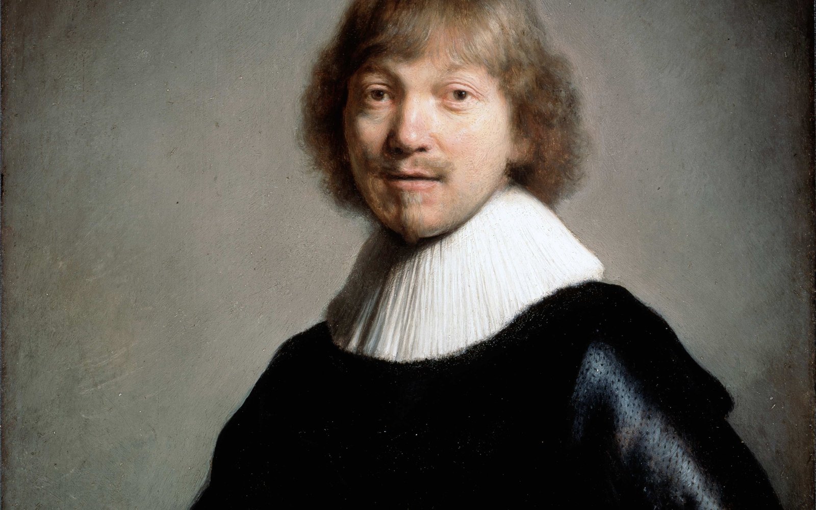 Portrait of a man in a black robe with a large white lace collar on a grey black background. He has longish hair and a goatee beard.