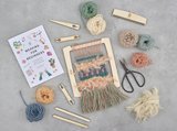 A weaving kit featuring scissors, colorful yarn, and additional crafting tools arranged neatly on a table.