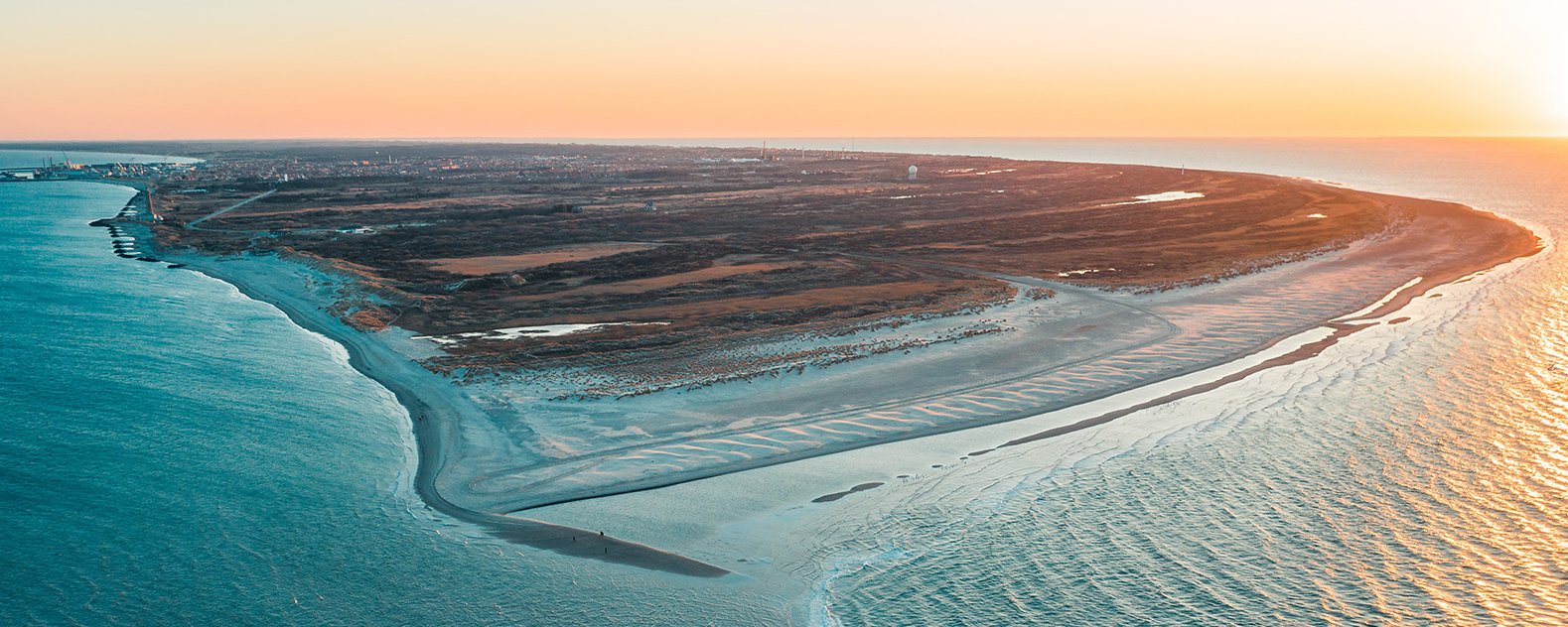 Beach peninsula during sunset from above.