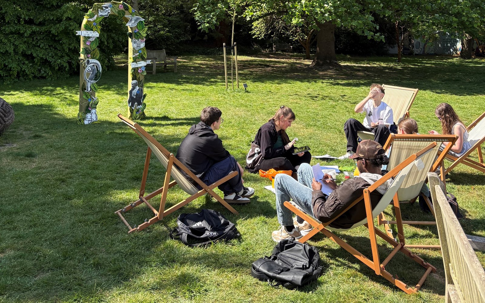 Small group sat in deck chairs in a garden.