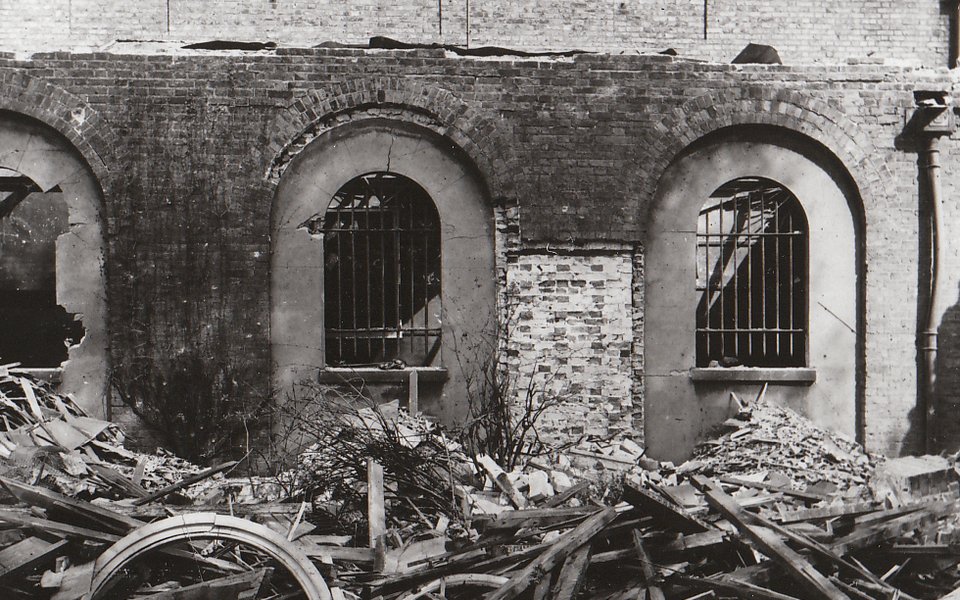 Black and white photograph showing the damage done to Dulwich Picture Gallery by a V2 bomb with collapsed walls and roof.