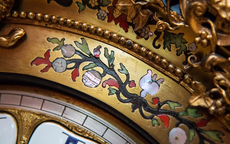 Close up of elaborate decoration on a clock.