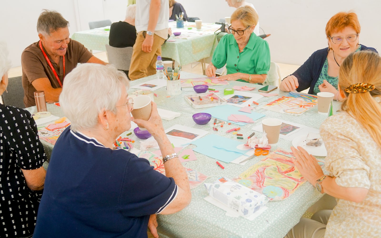 Group of older adults sat at a table making crafts