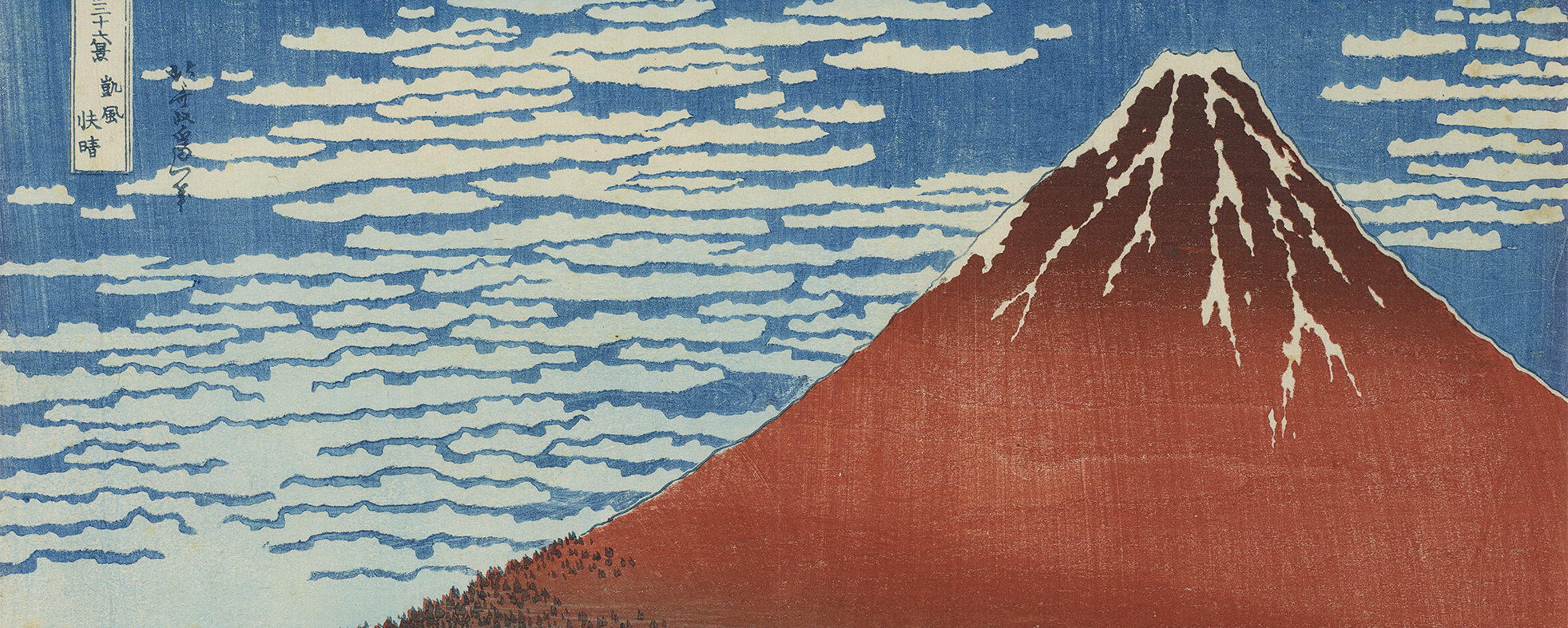 Woodblock print of Mount Fuji in red with snow top with a cloudy sky and trees below.