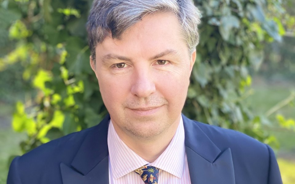 Portrait of a man wearing a blue suit, white shirt and tie